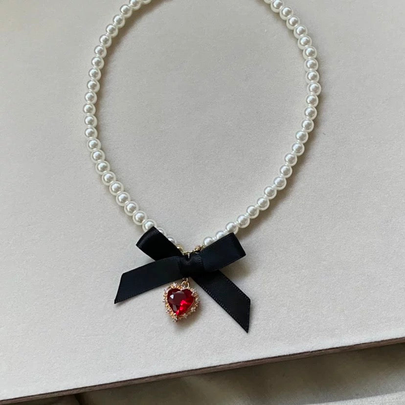 Collier avec pendentif en forme de nœud papillon et ruban en forme de cœur