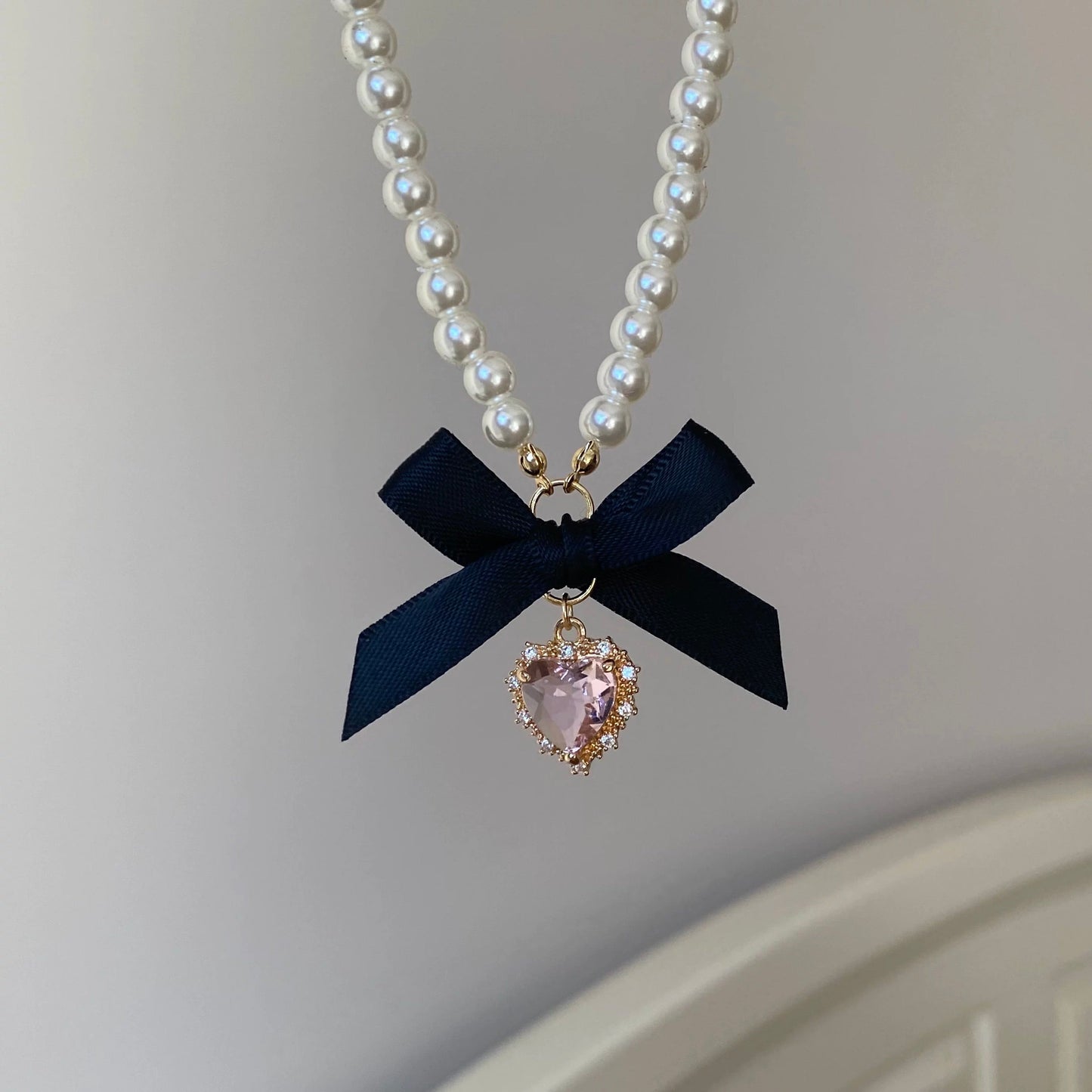 Collier avec pendentif en forme de nœud papillon et ruban en forme de cœur