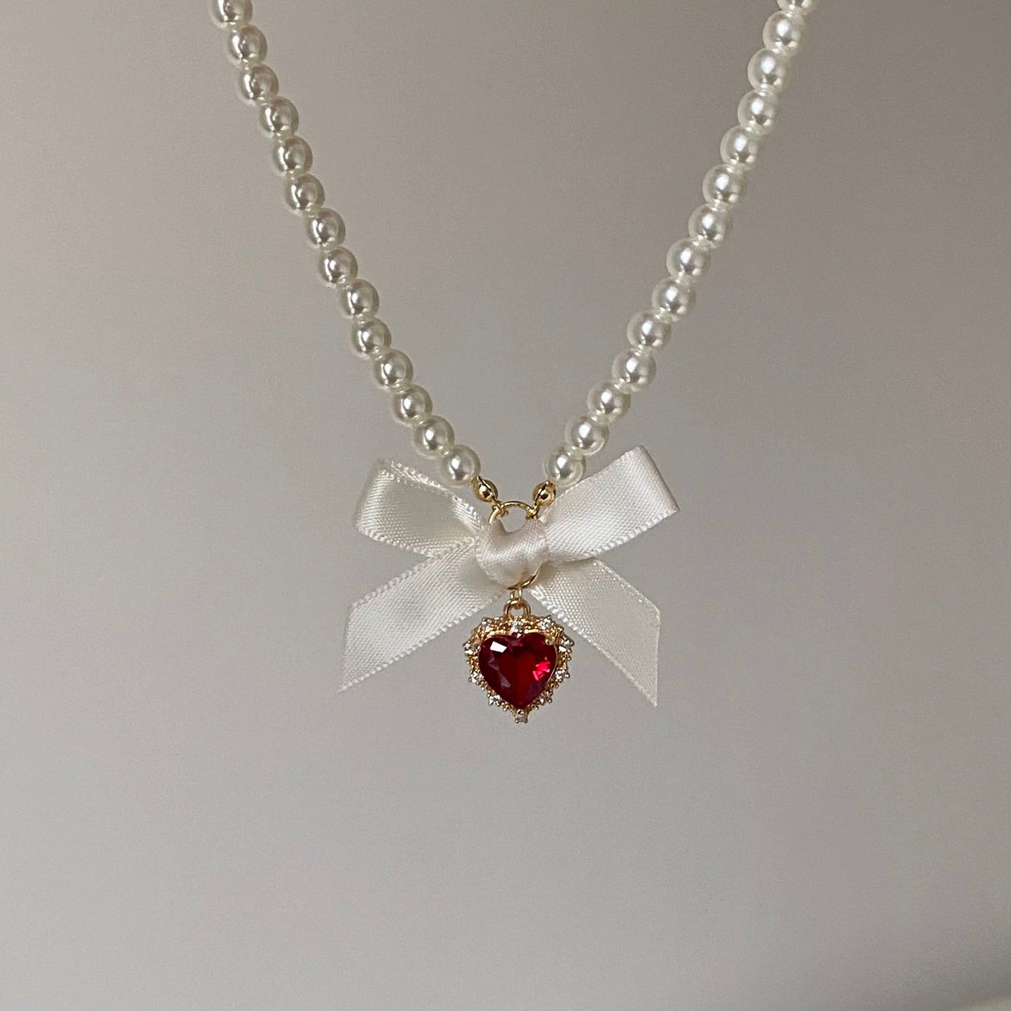 Collier avec pendentif en forme de nœud papillon et ruban en forme de cœur