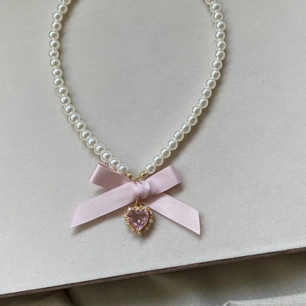 Collier avec pendentif en forme de nœud papillon et ruban en forme de cœur