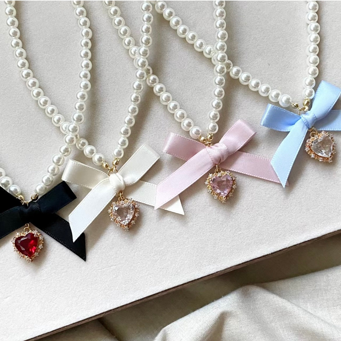 Collier avec pendentif en forme de nœud papillon et ruban en forme de cœur