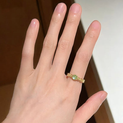 Eleganter offener Ring mit grünem Kristalleinlage